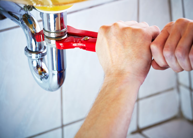 Plumbing-repairs Handyman loosening a drain to fix a clog