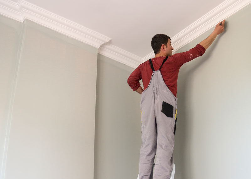 Small-Room-Painting Handyman painting a small room with crown Molding